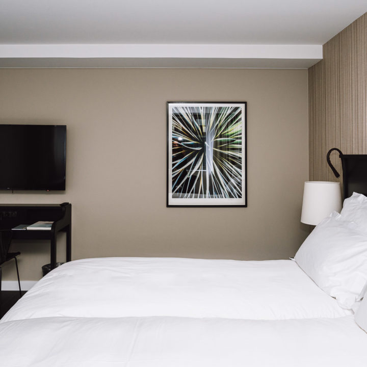 A big bed with white sheets in a hotel room