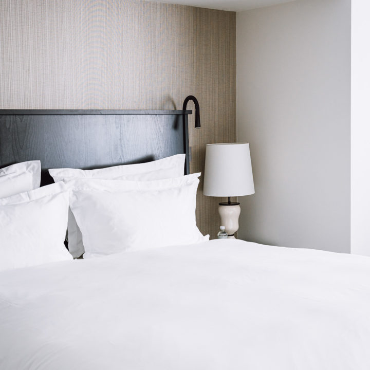 A bed with white sheets in a hotel room in Pillows Hotel Brussels Centre