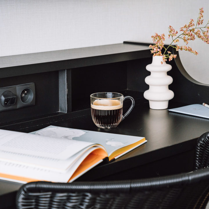 A cup of coffee a book on a black desk