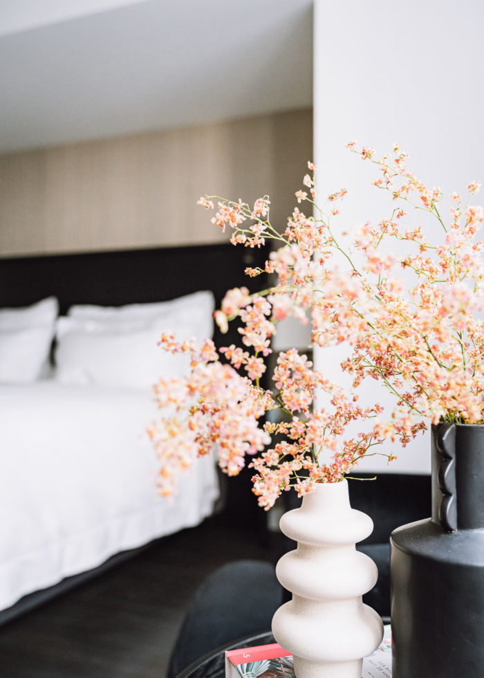 Flowers in a vase with a bed in the background