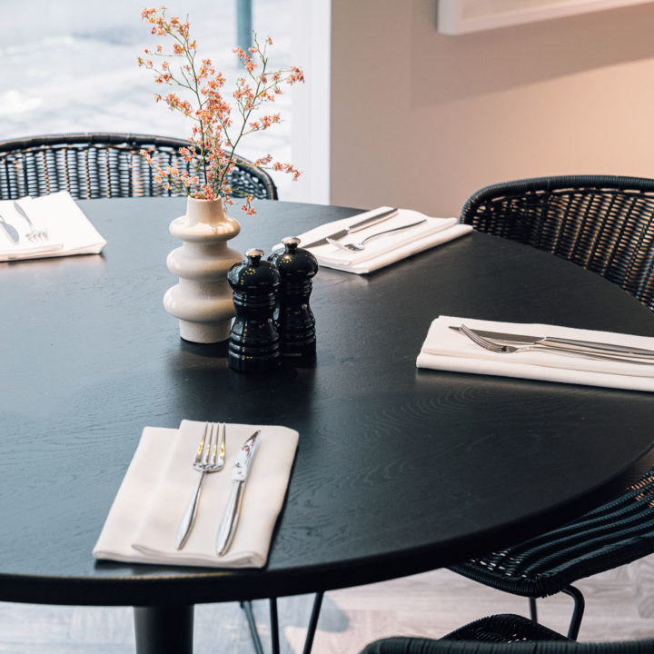 A set table with white napkins and silver cutlery