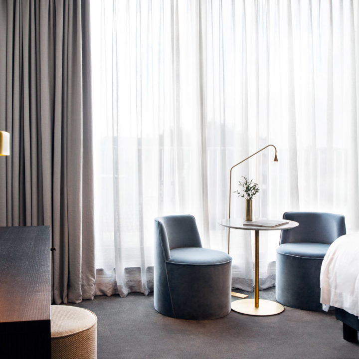 A bright hotel room with two chairs