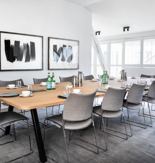 A meeting room with grey chairs and a large table