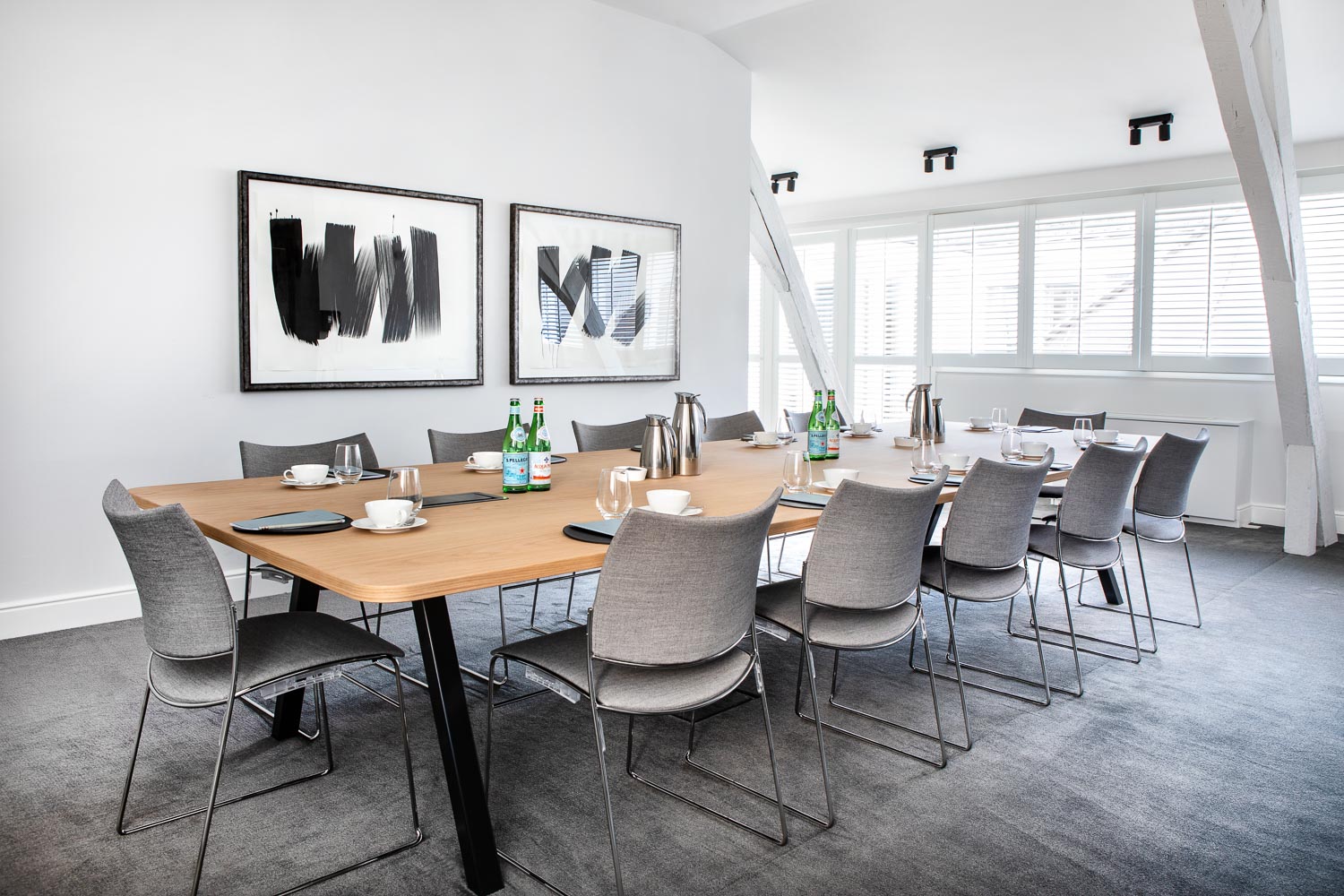 A meeting room with grey chairs and a large table