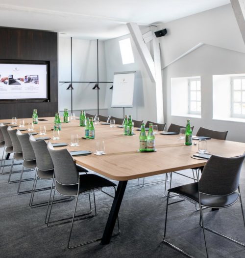 A bright meeting room table with black chairs in Pillows Hotel Reylof in Ghent