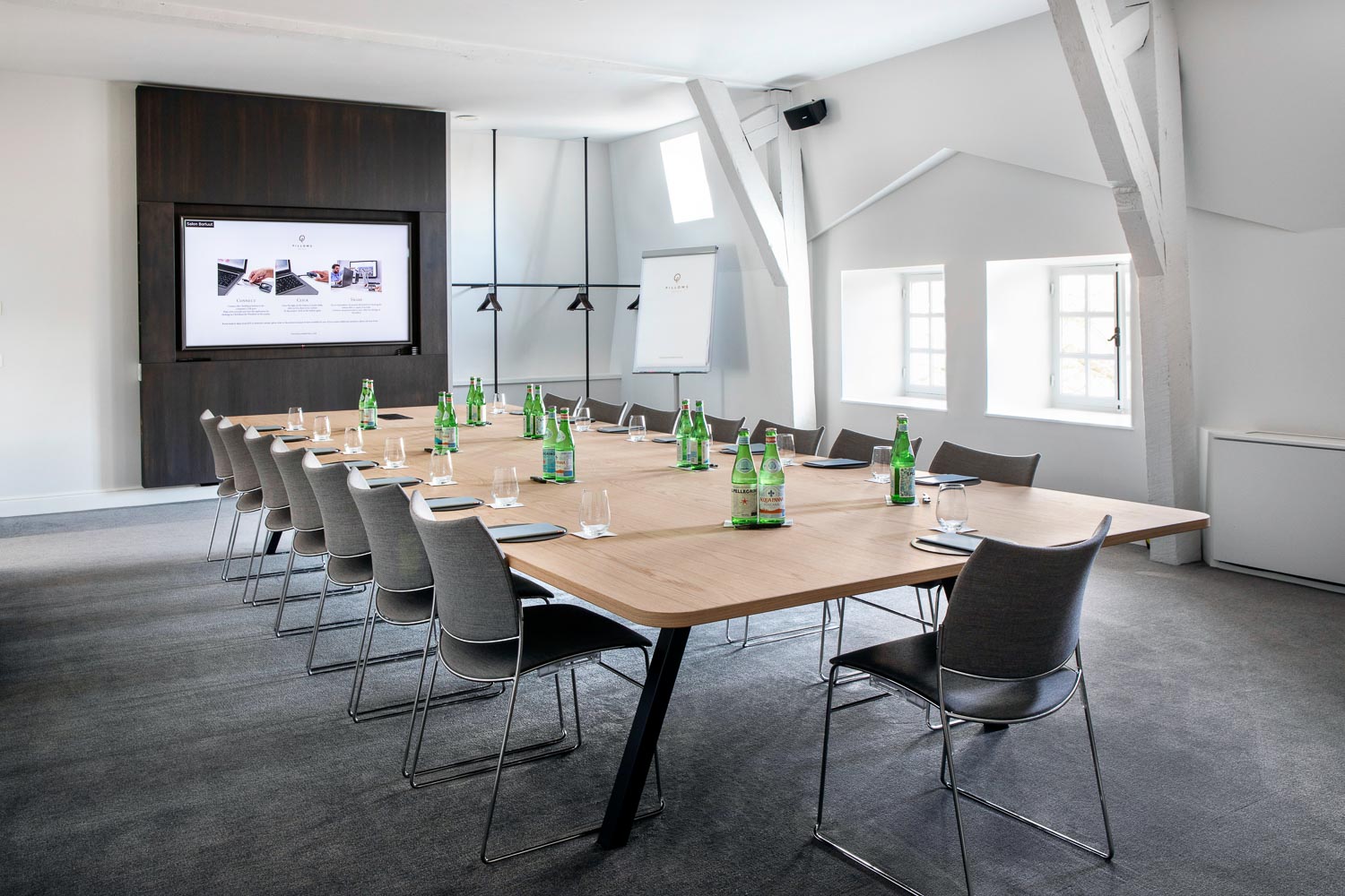 A bright meeting room table with black chairs in Pillows Hotel Reylof in Ghent