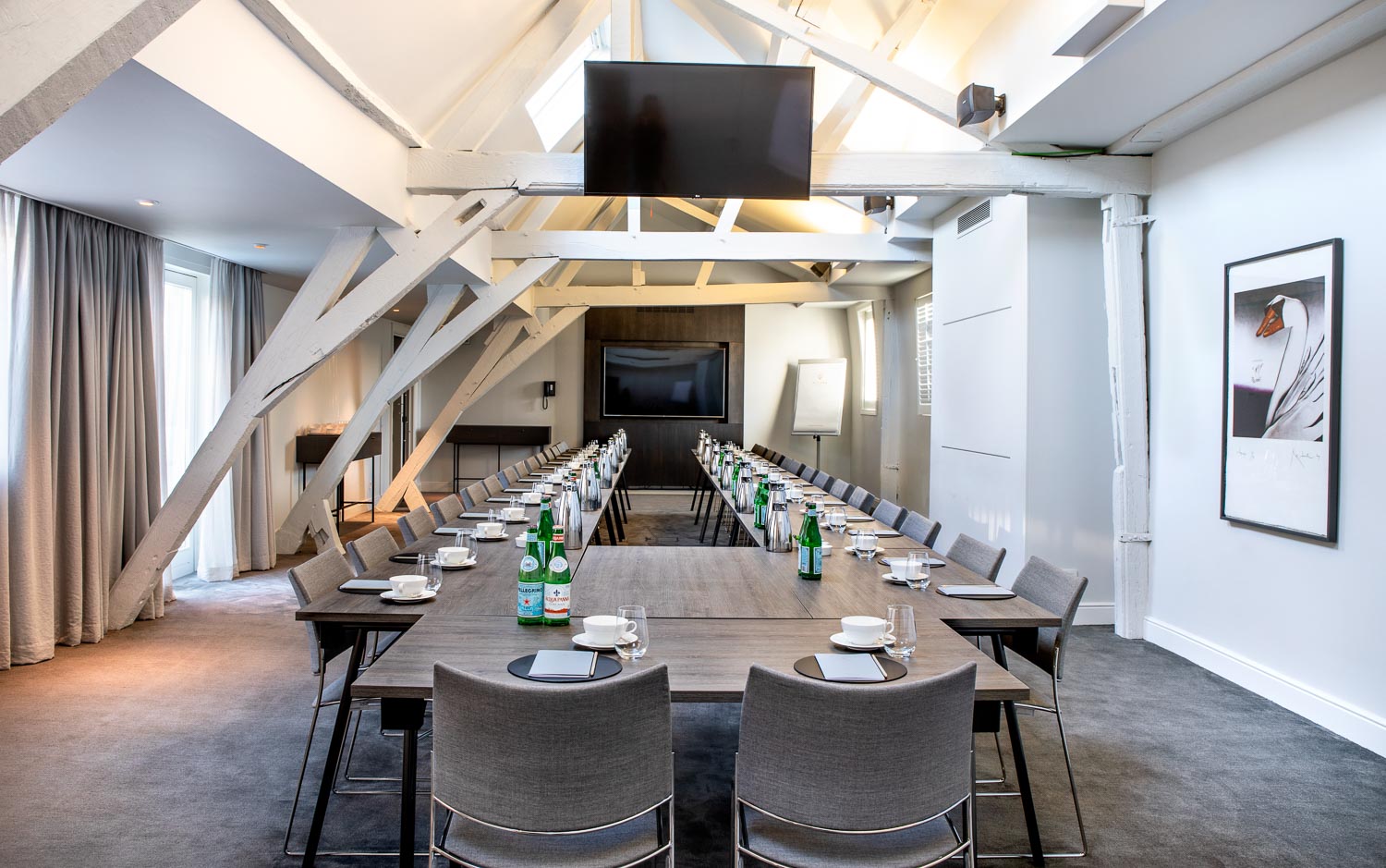 A bright meeting room with a long table and grey chairs in Pillows Hotel Reylof in Ghent