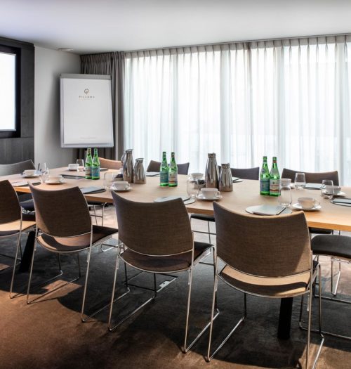 A bright meeting room table with grey chairs in Pillows Hotel Reylof in Ghent