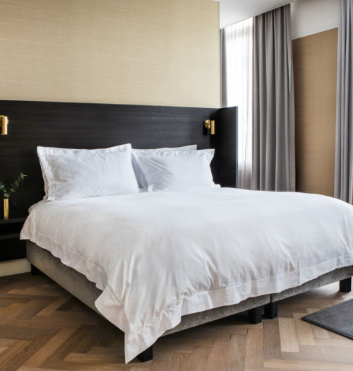 A king size bed with white linnen in the Suite of Pillows Grand Hotel Reylof in Ghent