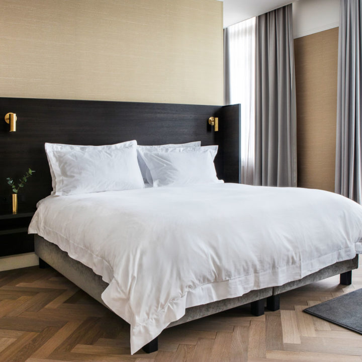 A king size bed with white linnen in the Suite of Pillows Grand Hotel Reylof in Ghent